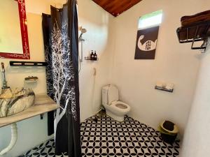 a small bathroom with a toilet and a sink at Nguyen Shack - Phong Nha Resort in Phong Nha