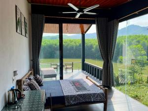 a room with a bed and a balcony with a view at Nguyen Shack - Phong Nha Resort in Phong Nha