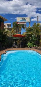 a large blue swimming pool in front of a hotel at Central Motel Nelson Bay in Nelson Bay