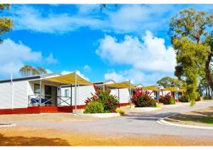 una fila de casas blancas con techos amarillos en Discovery Parks - Coffin Bay en Coffin Bay