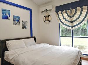 a bedroom with a bed and a window at Yussy Homestay at Afamosa Villa in Kampong Alor Gajah