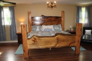 a large wooden bed in a bedroom with a chandelier at Climb On Inn - Red River Gorge Kentucky - Amazing Home ! 