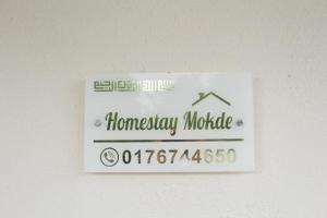 um sinal para um módulo de garantia doméstica numa parede em Homestay Mokde em Muar