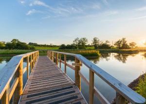 a wooden bridge over a body of water at Bowbrook Lodges in Pershore