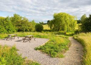 two picnic tables in a field with a path at Bowbrook Lodges in Pershore