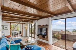 sala de estar con sofá azul y TV en @ Marbella Lane - 3BR Home w/sweeping ocean views!, en Pacífica