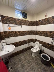 a bathroom with a toilet and a sink at KS PAYING GUEST HOUSE in Varanasi