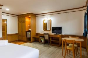 um quarto de hotel com uma cama e uma secretária e um quarto em The New Villa em Chaweng