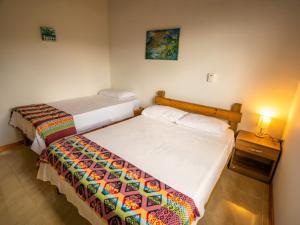 a bedroom with two beds and a table with a lamp at Frenchy's in Providencia