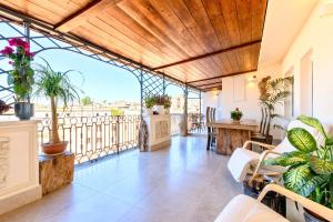 Habitación con balcón con mesa y sillas. en Atticus Forum Romanum Luxury Penthouse, en Roma