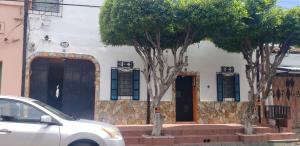 um carro branco estacionado em frente a uma casa com duas árvores em Mendoza’s GUEST HOUSE em Santa Ana