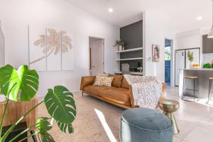 ein Wohnzimmer mit einem Sofa und einem Tisch in der Unterkunft Pembroke House - Inner city luxury in Cairns