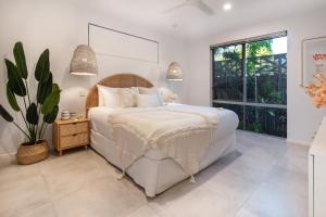 a bedroom with a bed and a large window at Pembroke House - Inner city luxury in Cairns