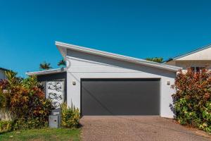 a garage with a gray garage door in front of a house at Pembroke House - Inner city luxury in Cairns