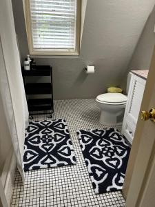 a bathroom with a toilet and a black and white rug at Unique Home Perfect for Large Gatherings. Pets welcome! in Orem