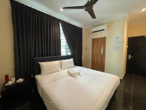 a bedroom with a large white bed with a ceiling at I Go Inn in Bandar Saujana Putra