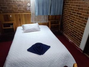 ein Schlafzimmer mit einem Bett mit blauem Hut darauf in der Unterkunft Hotel Real del Campo in Quetzaltenango
