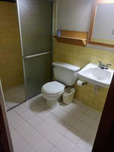 a bathroom with a toilet and a sink at Hotel Real del Campo in Quetzaltenango