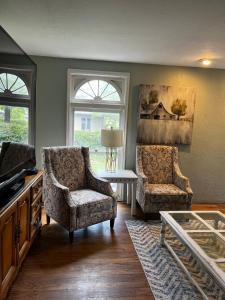 a living room with two chairs and a table at Unique Home Perfect for Large Gatherings. Pets welcome! in Orem