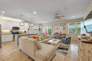 a living room with a couch and a kitchen at Coral Dreams in Gulf Shores