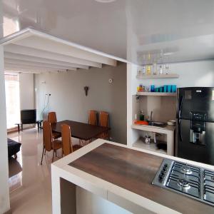 cocina y comedor con nevera negra en Conjunto Buganviles - Casa No 7 o 3, en Girardot