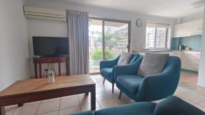- un salon avec deux chaises bleues et une table dans l'établissement K Resort Surfers Paradise Apartments, à Gold Coast
