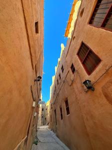 an alleyway between two buildings in an old town at AL Hamra Heritage Inn in Al Ḩamrāʼ