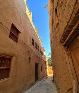un callejón entre dos edificios en un casco antiguo en AL Hamra Heritage Inn, en Al Ḩamrāʼ