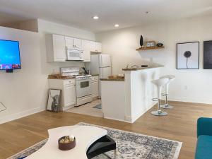 een woonkamer met een keuken met witte kasten bij Miami Downtown 5 people Apartment - 5 minutes to Bayfront Park in Miami