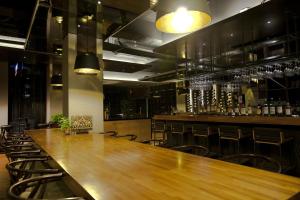 a large wooden table in a bar with chairs at Wolken Lodge in Hengchun