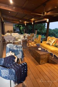 - un salon meublé sur une terrasse en bois dans l'établissement RICA RESIDENCE, à Dumbéa