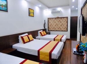 Habitación de hotel con 2 camas y TV de pantalla plana. en Tình Hiếu Hotel en Ha Long