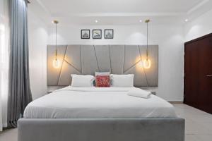 sypialnia z dużym białym łóżkiem z 2 lampami w obiekcie Luxury 3 Bedroom Apartment In Lekki Phase1 w mieście Lekki