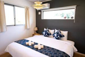 恩納的住宿－#3LDK一軒家 #長期滞在可能 #海まで4分-- Starry Sky Resort Okinawa --，一间卧室配有一张带两张蜡烛的床。