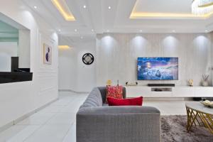 a living room with a couch and a tv at Luxury 3 Bedroom Apartment In Lekki Phase1 in Lekki