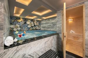 a jacuzzi tub in a bathroom with a floral wallpaper at Anatole Hotel Hanoi in Hanoi