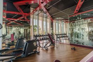 a gym with treadmills and exercise bikes in a room at GuestReady - Dubai Miracle Garden View Studio in Dubai