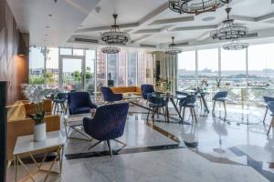 a lobby with chairs and tables and windows at GuestReady - Dubai Miracle Garden View Studio in Dubai