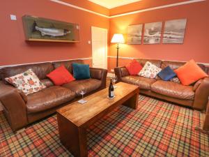 a living room with leather couches and a coffee table at The Old Smithy in Barnard Castle