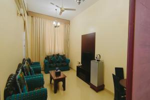 Khorfakkan Hotel Apartments في خور فكان: غرفة معيشة مع كرسيين وطاولة