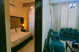 Khorfakkan Hotel Apartments في خور فكان: غرفة نوم بسرير وكرسي ازرق