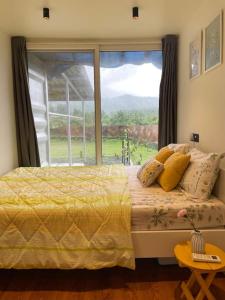 a bedroom with a bed and a large window at The Silver Lining - 2 bhk Villa facing the hills in Karjat +15 photos