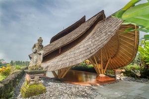 Weda Cita Resort and Spa by Mahaputra في أوبود: تمثال لامرأة تقف بجانب قارب