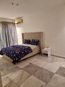 a bedroom with a bed with a blue comforter at Luxury 3 Bedroom with Pool and Gym In Oniru Victoria Island Lagos in Lagos