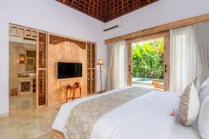 a bedroom with a large bed and a large window at Weda Cita Resort and Spa by Mahaputra in Ubud