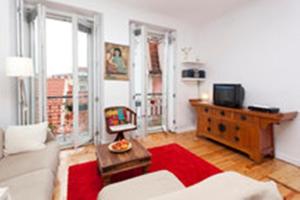 リスボンにあるApartamento Lisboaのリビングルーム(白いソファ、赤い敷物付)