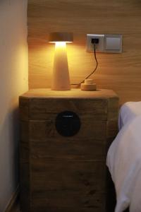 eine Lampe auf einem Nachttisch neben einem Bett in der Unterkunft Tulou Fuyulou Changdi Inn in Yongding