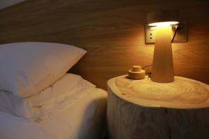 una lámpara en una mesa junto a una cama en Tulou Fuyulou Changdi Inn, en Yongding