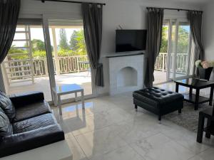 een woonkamer met een open haard en een televisie bij Villa Neyla Four bedroom Coral Bay Beach front in Coral Bay
