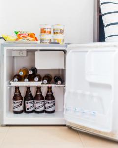 einen offenen Kühlschrank mit Flaschen Bier in der Unterkunft Bernis Hostel in Moalboal